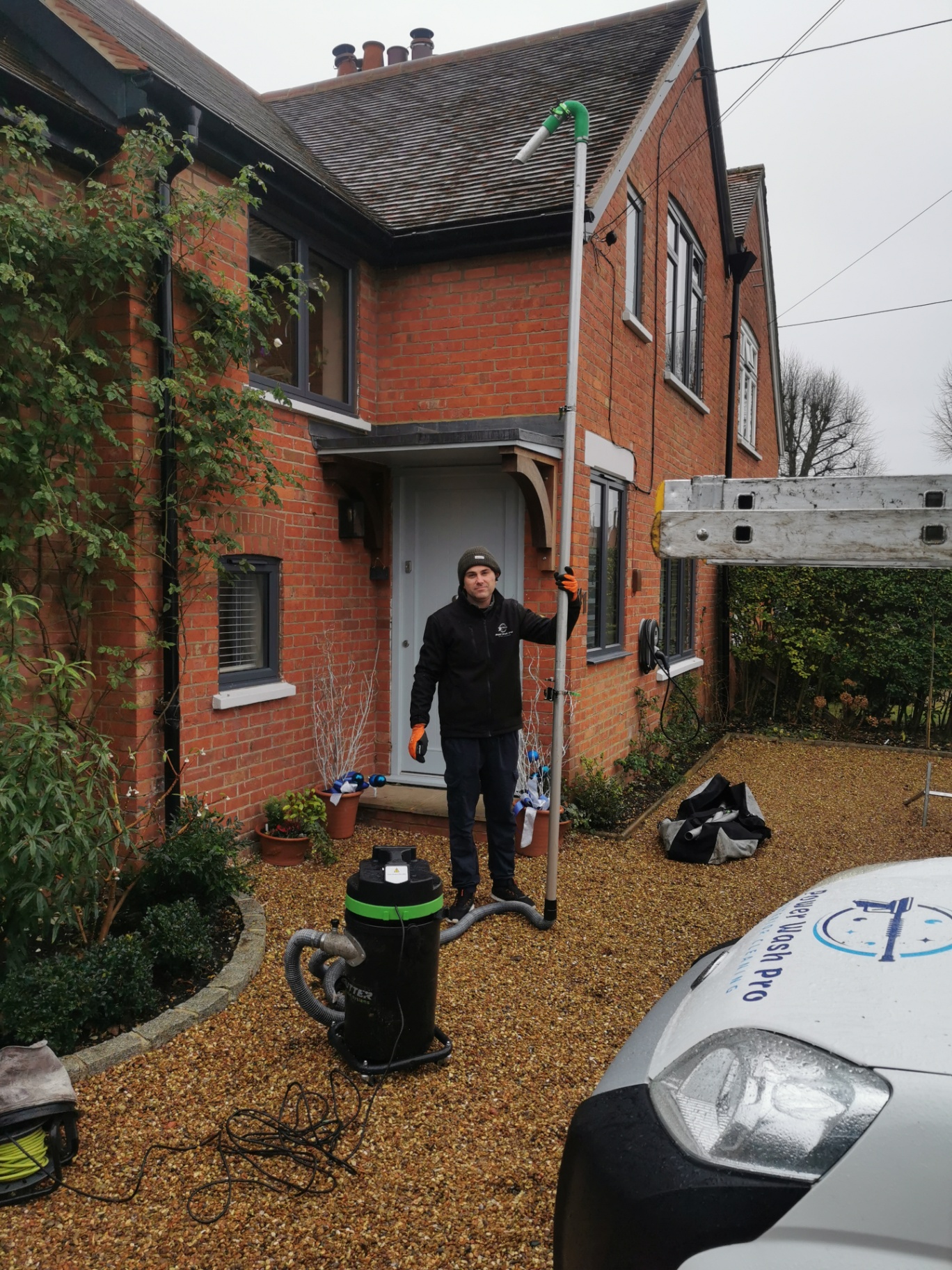Andrew clearing a gutter with a vacuum pole