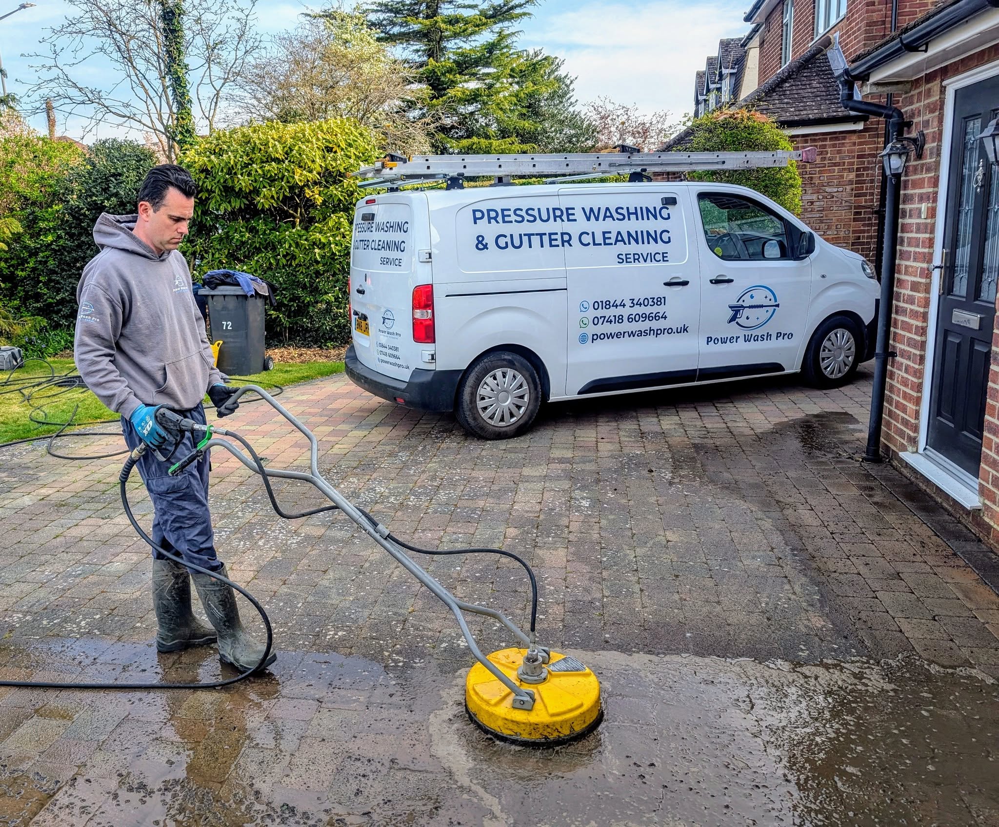 Andrew of Power Wash Pro pressure cleaning a paver driveway.